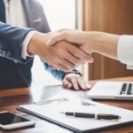 Comment Se Faire Racheter Son Crédit et Optimiser Ses Finances main-echangeant-un-contrat-de-pret-financier